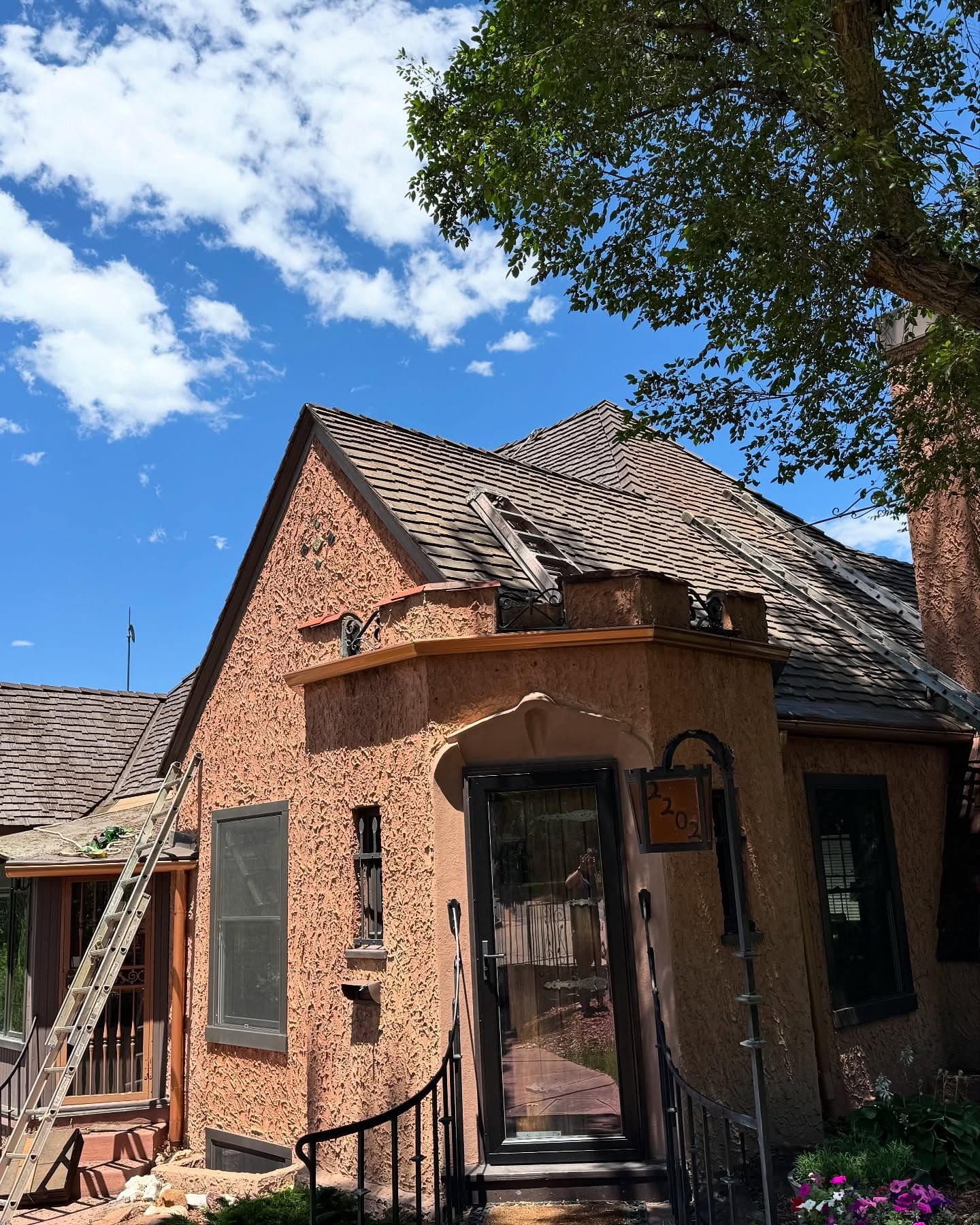 Brick residential house with dark roof against blue sky