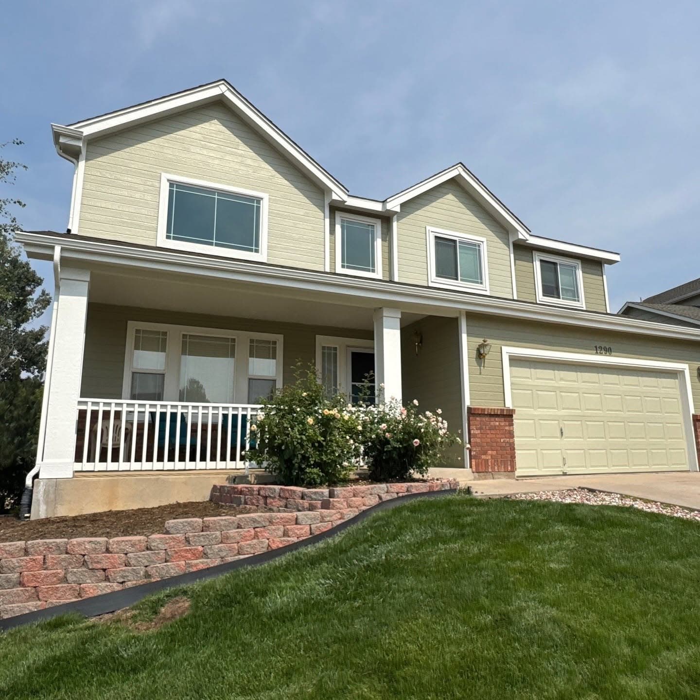 Cream siding two-story home with manicured landscaping