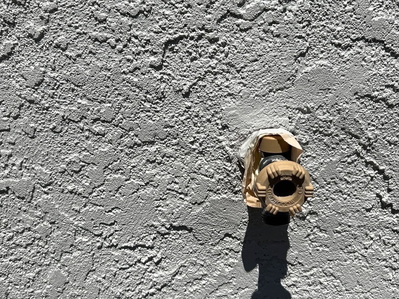Close-up of textured stucco finish with brass light fixture