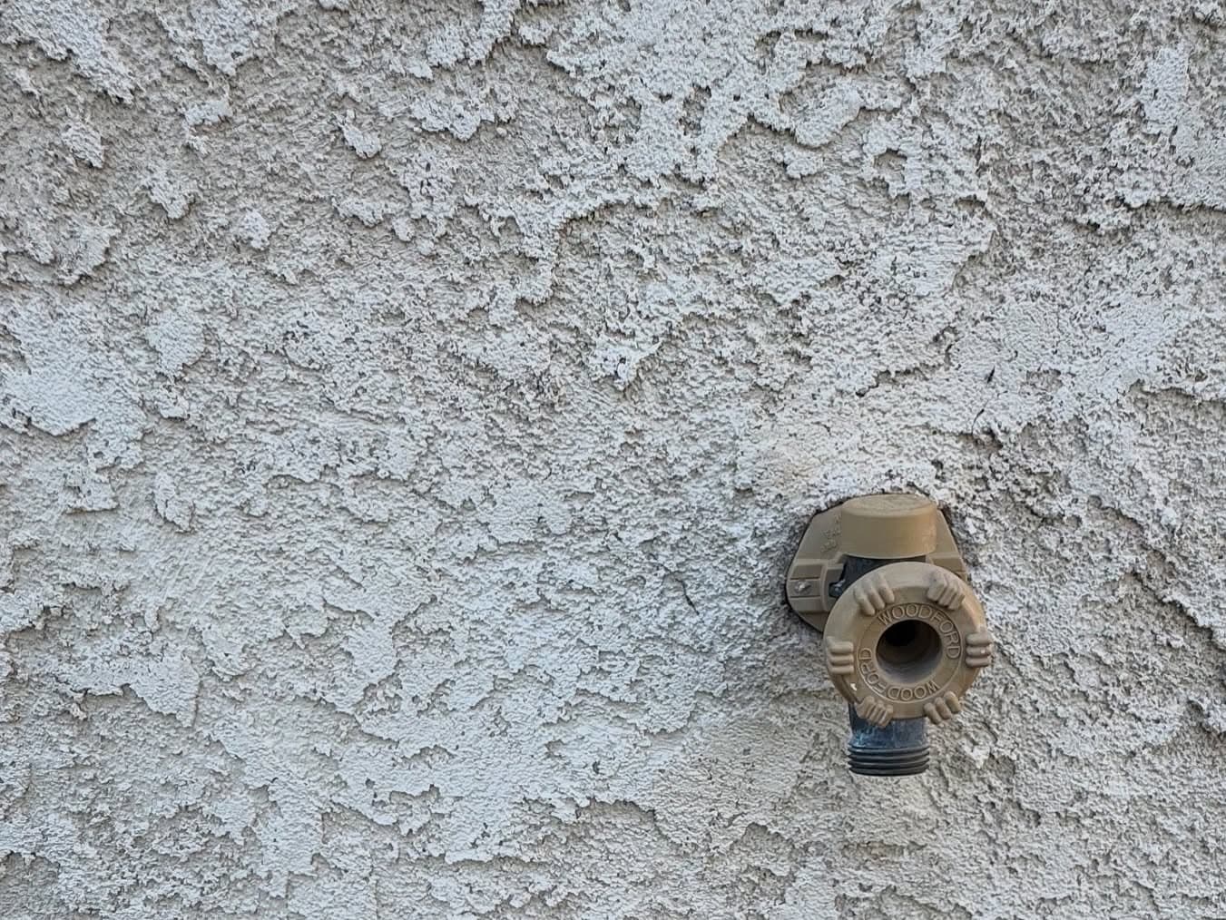 Close-up of textured stucco wall with brass light fixture